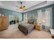 Spacious main bedroom with tray ceiling, ceiling fan, and adjacent office space at 1111 Carriage Park Dr, Valrico, FL 33594