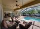 Beautiful patio with comfortable wicker furniture & dining area, perfect for entertaining by the pool at 1111 Carriage Park Dr, Valrico, FL 33594