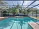Sparkling pool with screened enclosure, surrounded by lush landscaping and brick paving at 1111 Carriage Park Dr, Valrico, FL 33594