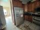 A kitchen with wooden cabinets, stainless steel refrigerator and range at 1530 Davenport Dr, New Port Richey, FL 34655
