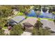 Aerial view showcasing a house with lush green lawns, mature trees, and a pond reflecting the sky, creating a serene setting at 15555 Martinmeadow Dr, Lithia, FL 33547