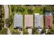 Aerial view of three homes showcasing their roof types, driveways and mature trees at 15555 Martinmeadow Dr, Lithia, FL 33547