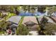 Aerial view of a residential neighborhood featuring houses with well-maintained lawns, and a community lake at 15555 Martinmeadow Dr, Lithia, FL 33547