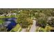 Aerial view featuring an expansive community with homes surrounded by lush trees and a pond at 15555 Martinmeadow Dr, Lithia, FL 33547