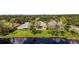 A row of houses overlook a serene pond, providing tranquil backyard views in a lush, green community at 15555 Martinmeadow Dr, Lithia, FL 33547