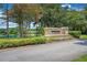 Attractive stone sign for Martin Meadow, surrounded by lush greenery and mature trees at 15555 Martinmeadow Dr, Lithia, FL 33547