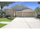 Charming home featuring a two-car garage, neutral stucco, and manicured landscaping at 15555 Martinmeadow Dr, Lithia, FL 33547