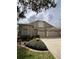 Charming home with a three-car garage, a well-manicured lawn, and mature landscaping at 15555 Martinmeadow Dr, Lithia, FL 33547
