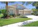 Charming home showcasing verdant lawn, colorful plants, and a three-car garage at 15555 Martinmeadow Dr, Lithia, FL 33547