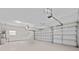 Spacious two car garage with white walls, a clean floor, and two overhead doors, offering ample parking and storage at 15555 Martinmeadow Dr, Lithia, FL 33547