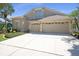 Two-story home featuring an attached three-car garage and spacious driveway at 15555 Martinmeadow Dr, Lithia, FL 33547