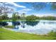 Picturesque pond featuring a grass shore and a variety of trees and shrubs around it at 15555 Martinmeadow Dr, Lithia, FL 33547