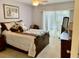 Comfortable bedroom with an ensuite bathroom, a ceiling fan, and sliding glass doors to the patio at 1655 S Highland Ave # J193, Clearwater, FL 33756