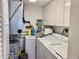 Bright laundry room featuring a washing machine, dryer, water heater, and ample white cabinet storage space at 1655 S Highland Ave # J193, Clearwater, FL 33756