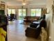 Spacious living room offers tile flooring, ceiling fan, and water views through sliding glass doors at 1655 S Highland Ave # J193, Clearwater, FL 33756
