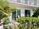 Outdoor patio features a round table with chairs, sliding glass doors, and lush tropical landscaping at 1655 S Highland Ave # J193, Clearwater, FL 33756