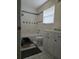 Standard bathroom with tiled shower-tub, white cabinets, and a window at 1735 Tall Pine Cir, Safety Harbor, FL 34695