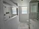 Bright bathroom with a glass-enclosed shower, large mirror, and window for natural light at 1735 Tall Pine Cir, Safety Harbor, FL 34695