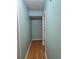 Neutral narrow hallway offering hardwood flooring and access to other rooms at 1735 Tall Pine Cir, Safety Harbor, FL 34695