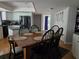 Eat-in kitchen features stainless appliances, white cabinetry, island cooktop, and a wooden dining set for six at 1735 Tall Pine Cir, Safety Harbor, FL 34695