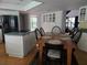 Eat-in kitchen features stainless appliances, white cabinetry, island cooktop, and a wooden dining set for six at 1735 Tall Pine Cir, Safety Harbor, FL 34695