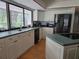 Well-lit kitchen boasts white cabinets, stainless steel refrigerator, and a large window with backyard views at 1735 Tall Pine Cir, Safety Harbor, FL 34695