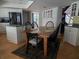 Eat-in kitchen features stainless appliances, white cabinetry, island cooktop, and a wooden dining set for six at 1735 Tall Pine Cir, Safety Harbor, FL 34695