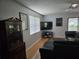Living room offering a large television, cabinet storage, and access to outdoor views and natural light at 1735 Tall Pine Cir, Safety Harbor, FL 34695