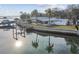 Waterfront home with a dock, lush landscaping, and serene water views at 1897 Clearwater Harbor Dr, Largo, FL 33770