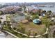 Aerial view of a community park featuring tennis courts, playground, picnic pavilion, and palm tree landscaping at 211 Bath Club N Blvd, North Redington Beach, FL 33708