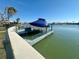 Waterfront property features private boat dock with boat lift and a boat covered in blue at 211 Bath Club N Blvd, North Redington Beach, FL 33708