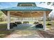 Covered community pavilion featuring picnic benches, with views to palm trees and neighborhood homes at 211 Bath Club N Blvd, North Redington Beach, FL 33708