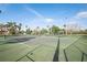 View of community tennis courts with palm tree landscaping, with gazebo and playground in the background at 211 Bath Club N Blvd, North Redington Beach, FL 33708
