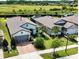 Aerial view of a well-maintained home with a manicured lawn, patio, and lush landscaping at 4748 Ballast Crest Cv, Land O Lakes, FL 34638