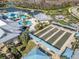 Aerial view of a community with a large pool, bocce ball courts, and picturesque water features at 4748 Ballast Crest Cv, Land O Lakes, FL 34638