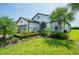 Beautiful home with manicured lawn, mature palm trees and lush landscaping creating curb appeal at 4748 Ballast Crest Cv, Land O Lakes, FL 34638