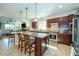 Open kitchen featuring a large island, pendant lighting, stainless steel appliances, and dark wood cabinets at 4748 Ballast Crest Cv, Land O Lakes, FL 34638