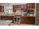 Kitchen featuring stainless appliances, gas range, granite countertops, and dark wood cabinets at 4748 Ballast Crest Cv, Land O Lakes, FL 34638