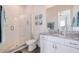 Bathroom featuring a glass shower, decorative art, granite countertop, and ample vanity storage at 11721 1St E St, Treasure Island, FL 33706
