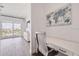 Home office space with a white desk and chair overlooking the water and a TV on the wall at 11721 1St E St, Treasure Island, FL 33706