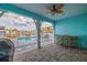 View of outdoor patio with ceiling fan overlooking the community pool and waterway at 11721 1St E St, Treasure Island, FL 33706