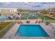 Aerial view of a private pool overlooking the water with lounge chairs, table and boat docks at 11721 1St E St, Treasure Island, FL 33706