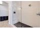Modern glass shower with a bench, rainfall showerhead and dark pebble flooring at 11721 1St E St, Treasure Island, FL 33706