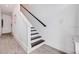 Modern stairway with sleek design, white risers, and a dark handrail, and wood floors at 11721 1St E St, Treasure Island, FL 33706