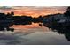 Tranquil water view at sunset with boats docked along the canal and reflections of the colorful sky and buildings at 11721 1St E St, Treasure Island, FL 33706