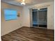 Bedroom with vinyl floors, a window, and a sliding glass door to the patio at 401 Dorchester Pl # 62, Sun City Center, FL 33573