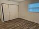 Spacious bedroom featuring wood-look floors and a window that provides natural light at 401 Dorchester Pl # 62, Sun City Center, FL 33573