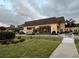 Beautiful community building with inviting entrance, mature landscaping, and walkway at 401 Dorchester Pl # 62, Sun City Center, FL 33573