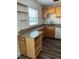 Well-lit kitchen featuring granite countertops, wood cabinets, and wood-look flooring at 401 Dorchester Pl # 62, Sun City Center, FL 33573