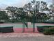 Outdoor tennis court fenced with tall trees around at 401 Dorchester Pl # 62, Sun City Center, FL 33573